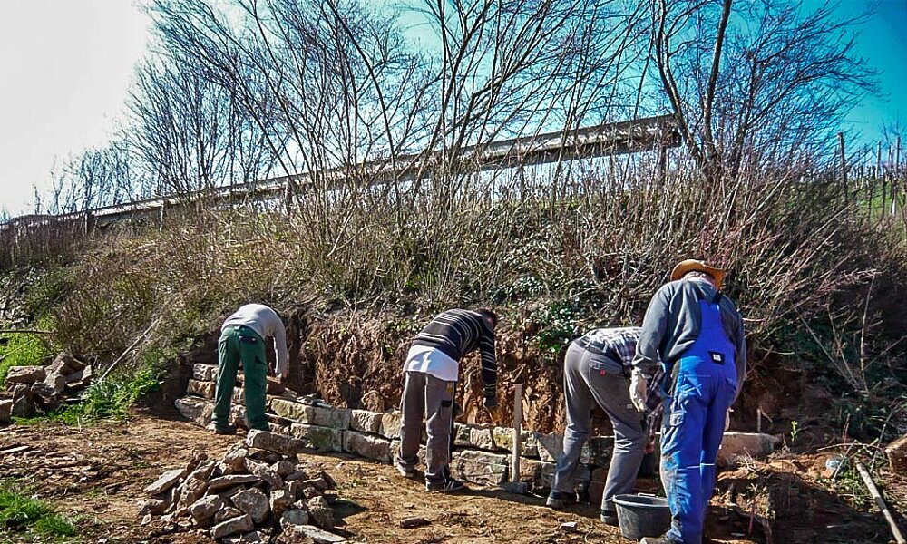 Arbeiter beim errichten einer Trockenmauer