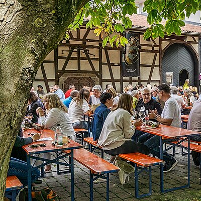 Menschen auf Bierbänken beim Weinfest